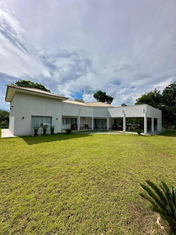 a large white building with a large grass yard at Chácara Segredo in Bonito