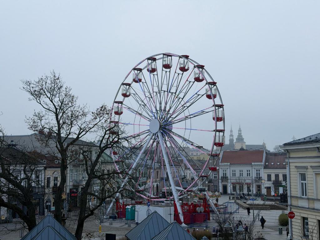 ein Riesenrad mitten in einer Stadt in der Unterkunft Paris Rooms -Rynek Centrum -F VAT in Kielce