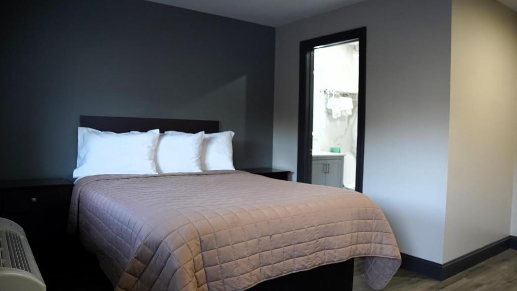 ein Schlafzimmer mit einem Bett mit weißen Kissen und einem Fenster in der Unterkunft Best Way Inn in Middlefield