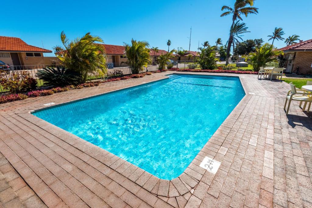 a swimming pool in a yard with a brick patio at Hospitality Carnarvon, SureStay by Best Western in Carnarvon