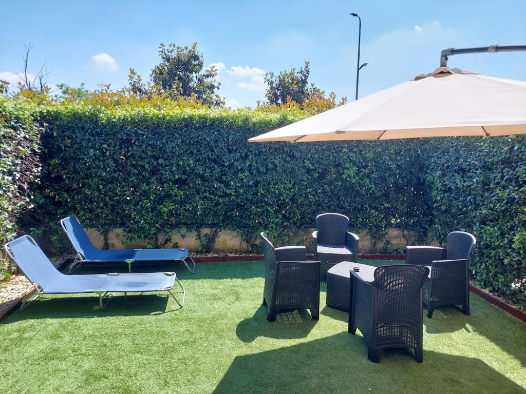 アッサーゴにあるApartment Vittoria Assago Forumのパティオ(椅子、テーブル、パラソル付)