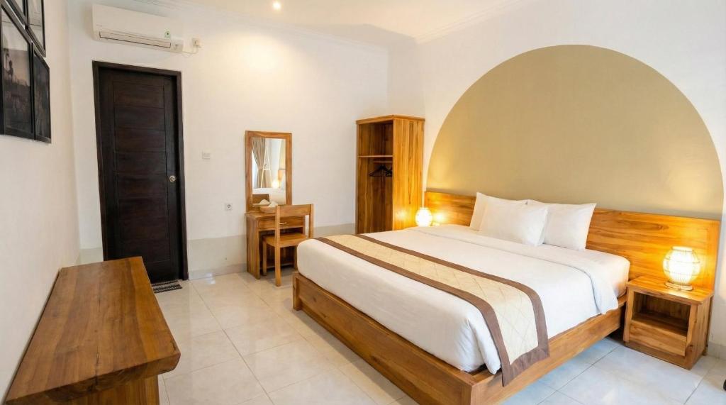 a bedroom with a bed and a table in a room at Room #5 Mari Posa Cottage in Badung