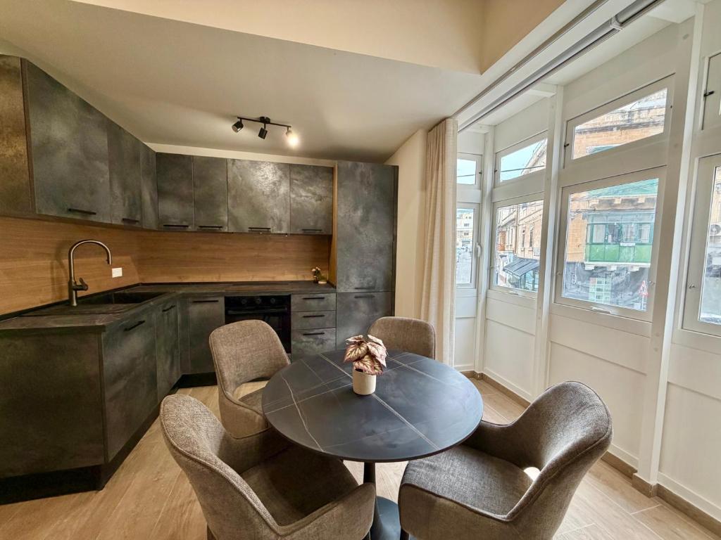 a kitchen with a table and chairs and a counter at The Rue in Il-Gżira