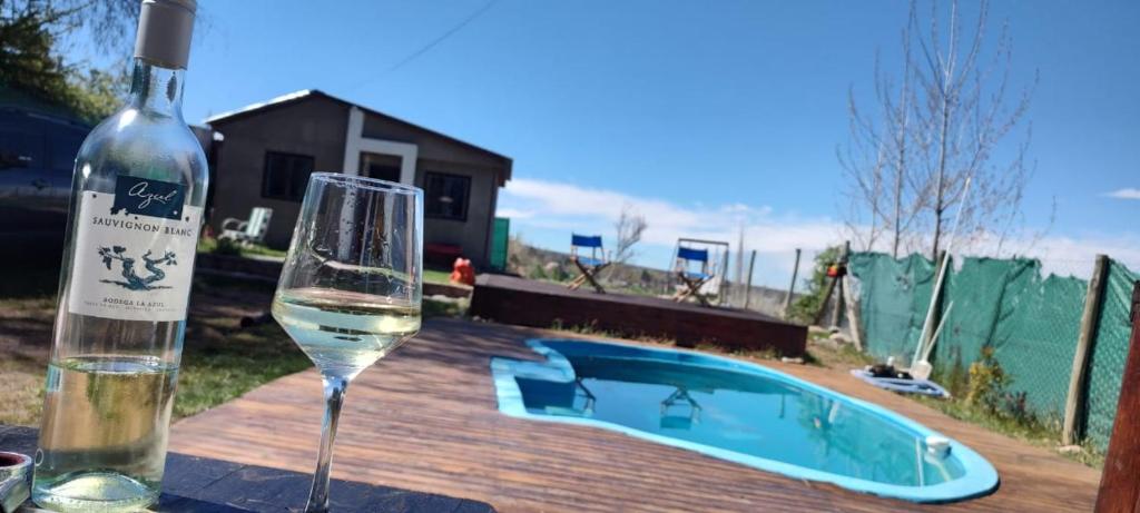 Cabaña la morocha في سيوداد لوجان دي كويو: كوب من النبيذ بجوار زجاجة من النبيذ