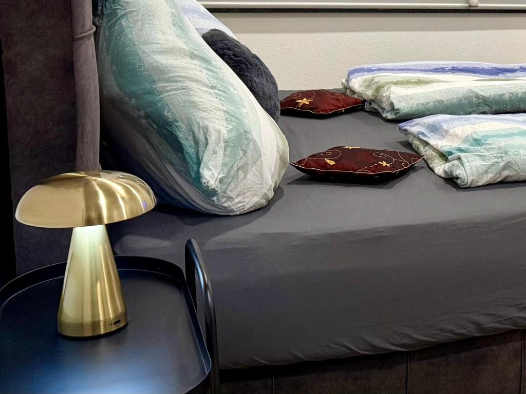a bed with two pillows and a table with a lamp at NEU wunderschöne Goldstadt Suite am Schlössle Zentrum Pforzheim in Pforzheim