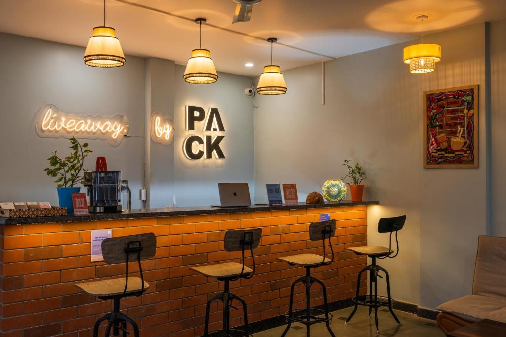 a bar in a restaurant with stools at LiveAway Rishikesh, Laxman Jhula by PACK in Rishīkesh