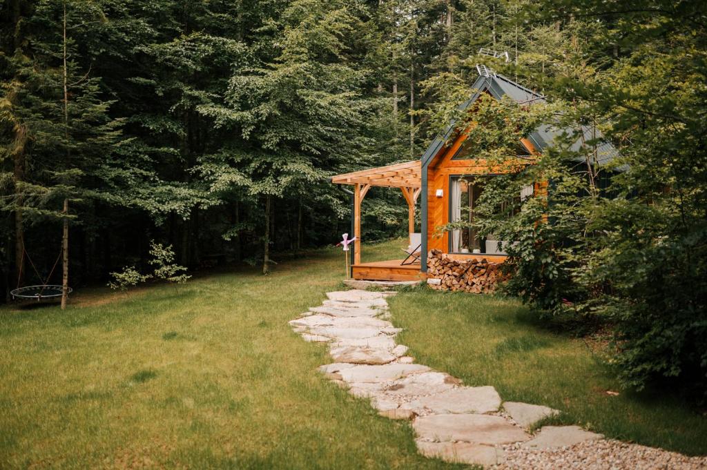 Tiny house nad potokiem في Ohłypów: شرفة في ساحة مع مسار حجري