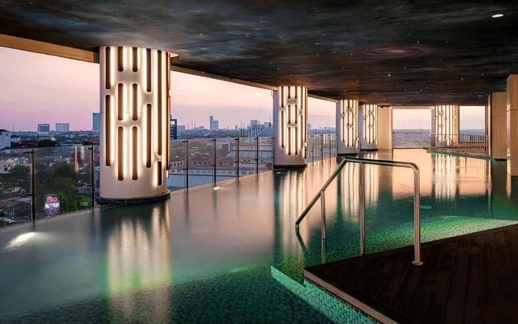 a swimming pool on the top of a building at Signature 2BR Apartment ARC100 Vasa Suite Surabaya City Centre with Balcony by Le Ciel Hospitality in Surabaya