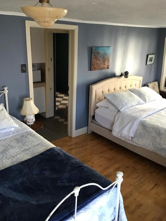 罗贝瓦勒Chez Odette, suite international的一间卧室，有两张床和一面蓝色的墙