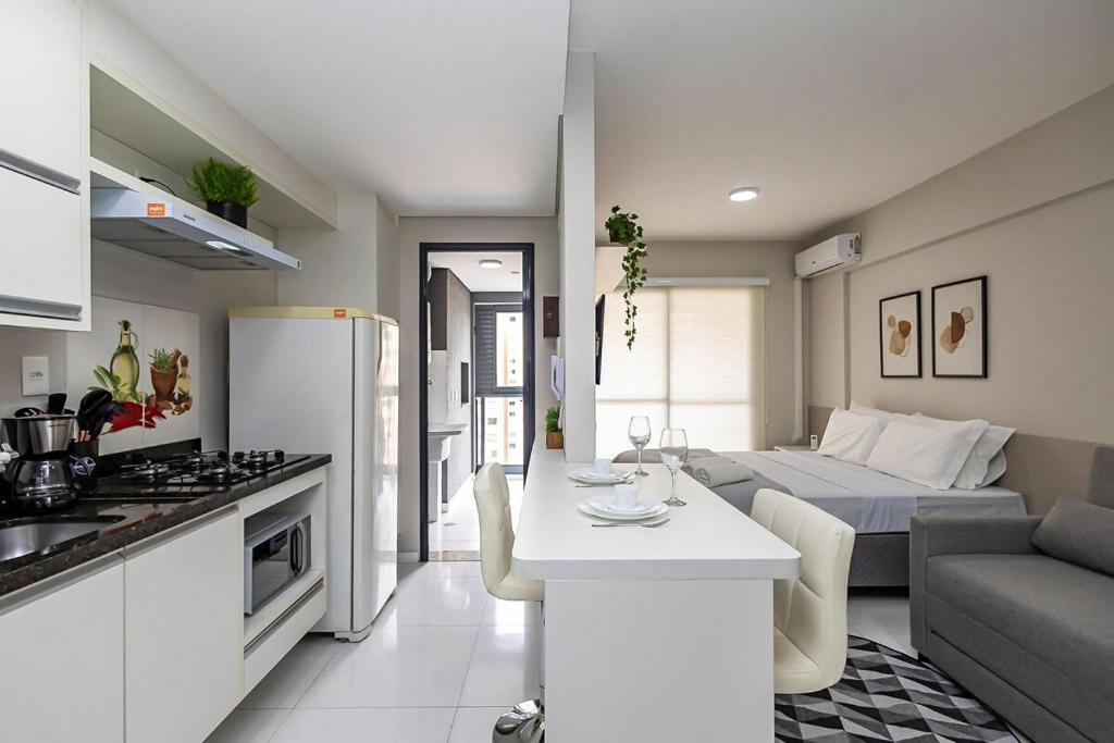a kitchen and living room with a table and a couch at Edifício Champagnat Office in Curitiba