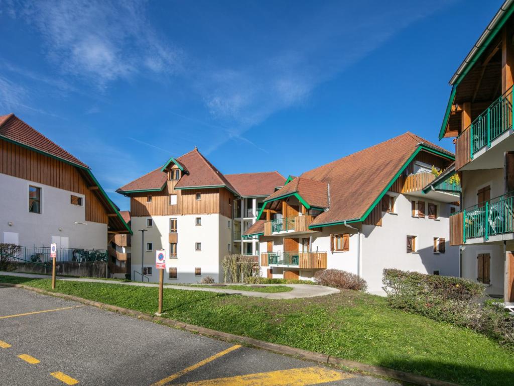 a row of apartment buildings with brown roofs at Résidence Vacancéole - Le Birdie in Giez