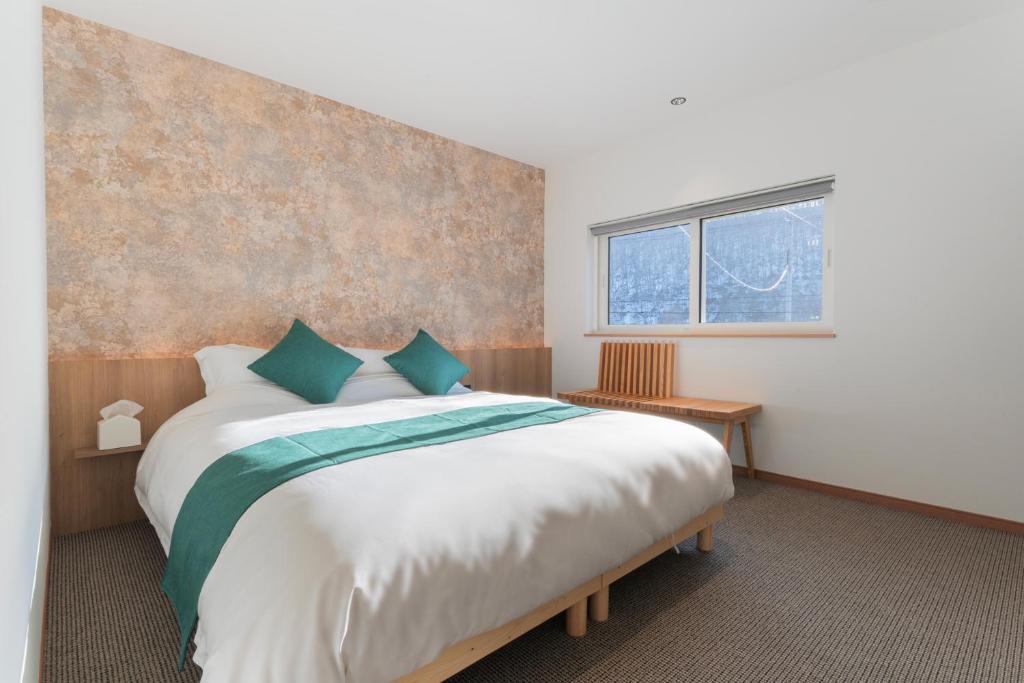 a bedroom with a large bed and a window at 美瑛の一棟貸切古民家 - Nature Retreat Ubaku Villa in Biei