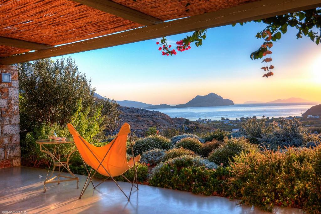 a patio with a table and chairs and a view of the ocean at Villa Handras-Main villa, by Amorgos Holiday Homes in Amorgos