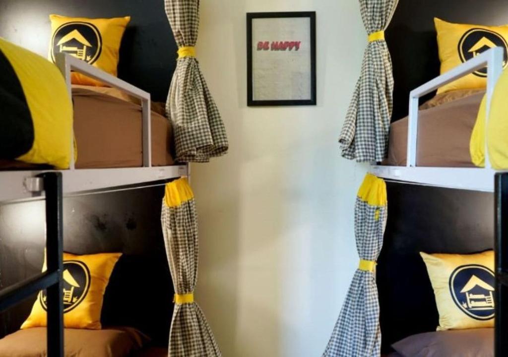 una habitación con literas con cortinas y almohadas en The Hosteller Delhi, International Airport, en Nueva Delhi