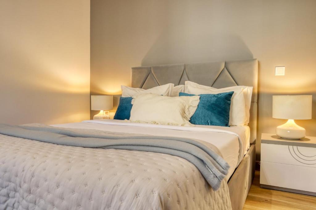 ein Schlafzimmer mit einem großen Bett mit blauen und weißen Kissen in der Unterkunft Casa dos Anjos, a Home in Madeira in Lombo Galego