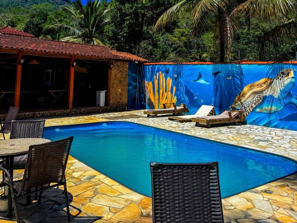 a swimming pool with a mural of a mermaid at Pousada Recanto dos Lima in Praia do Bananal