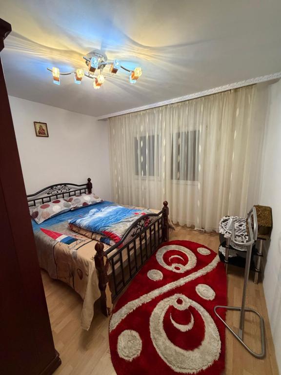 a bedroom with a bed and a red carpet at Apartament in Craiova in Craiova