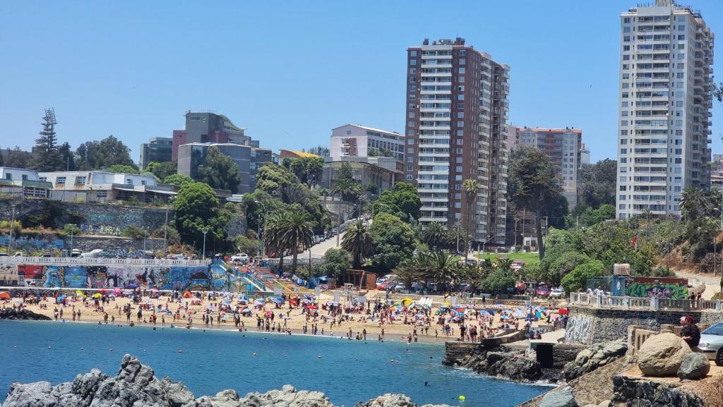 a group of people on a beach with buildings at Vacaciones frente al Mar in Valparaíso