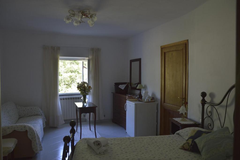 a bedroom with a bed and a chair and a window at Agriturismo Millefiori in Levanto