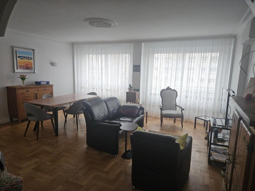 Chambre d'hôte dans appartement Lyon 69006 في ليون: غرفة معيشة بها طاولة وكراسي