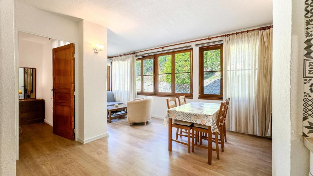 une salle à manger avec une table et des chaises dans une pièce dans l'établissement El racó de Montana Park, à Enveitg