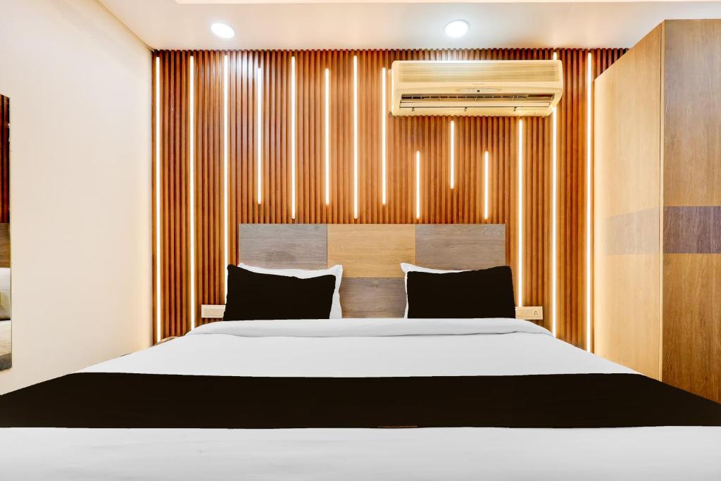 1 dormitorio con 1 cama grande y pared de madera en Hotel O Shalimar, en Ghaziabad