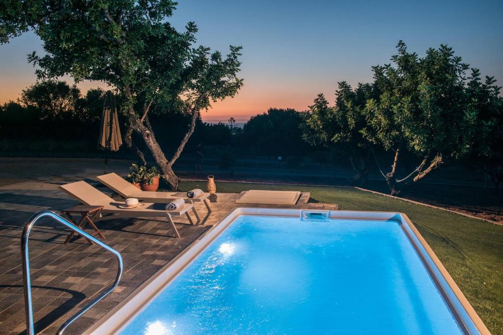 una piscina in un cortile con tavolo e sedie di Villa Roza by Prime Stay a Stalida