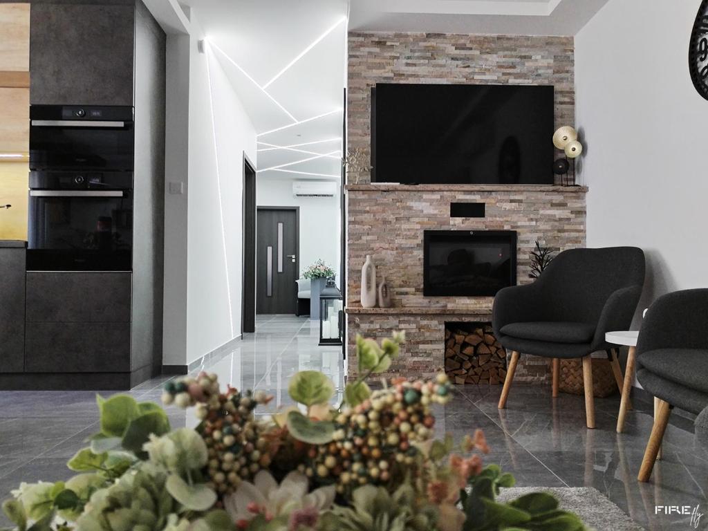 a living room with a fireplace and a tv at Noszvaj Vendégház in Noszvaj