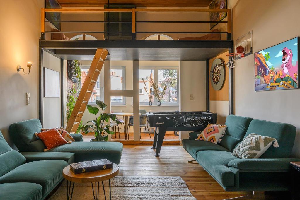 a living room with green couches and a loft bed at Boogas House - Gdańsk in Gdańsk