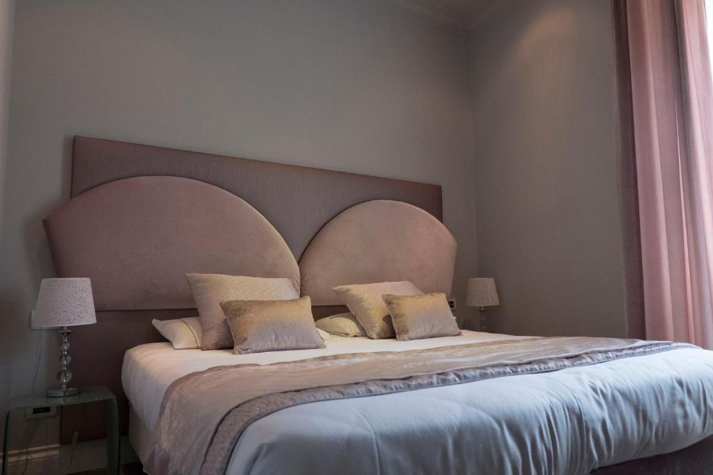 a bedroom with a large bed with a large headboard at Opera House Guest, Roma centro storico in Rome