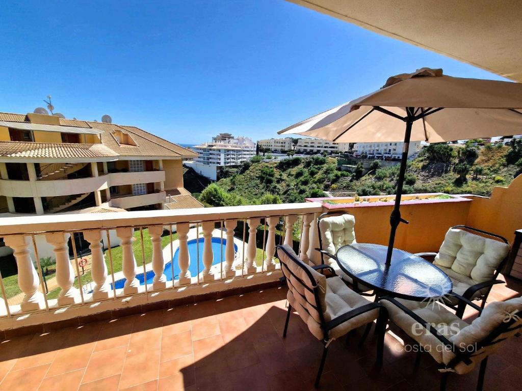 een balkon met een parasol en een tafel en stoelen bij Close To The Beach, With A Pool 224 in Las Lagunas Mijas