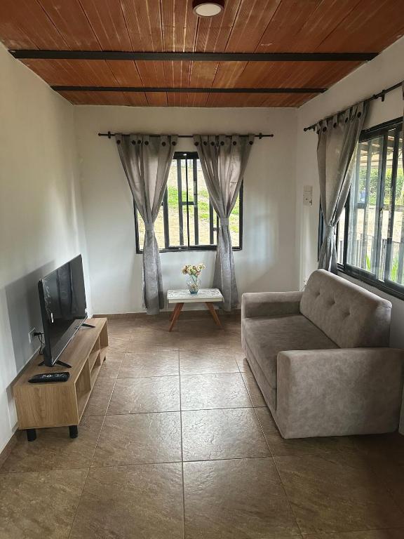 a living room with a couch and a tv at Casa Campestre acogedora y con aventura al alcance in San Gil