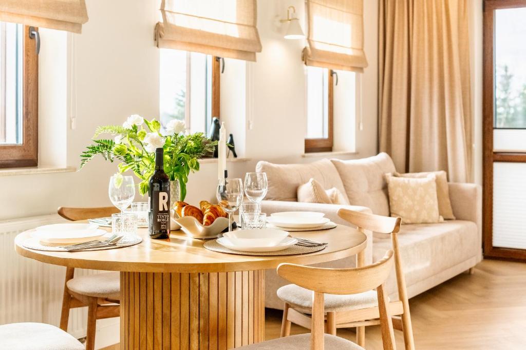 a living room with a table and a couch at Wino&Grono Nałęczów in Nałęczów