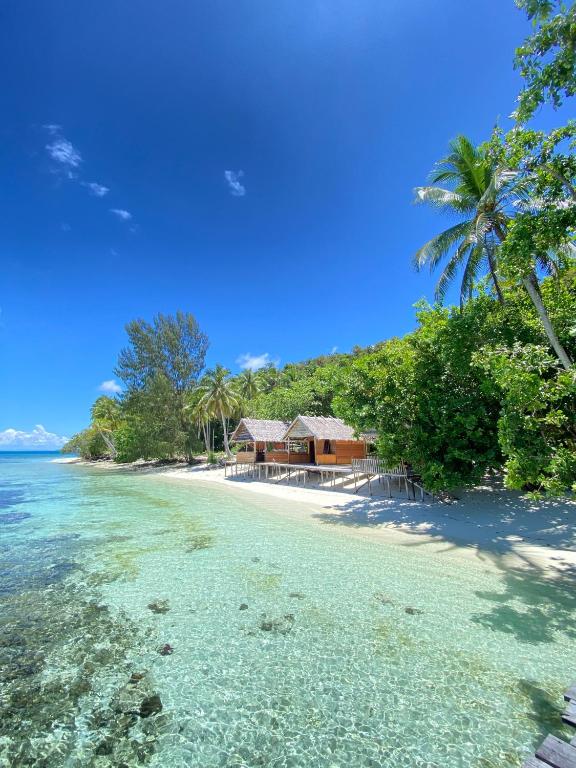 a resort on a beach with clear water at Marlina Homestay in Fam