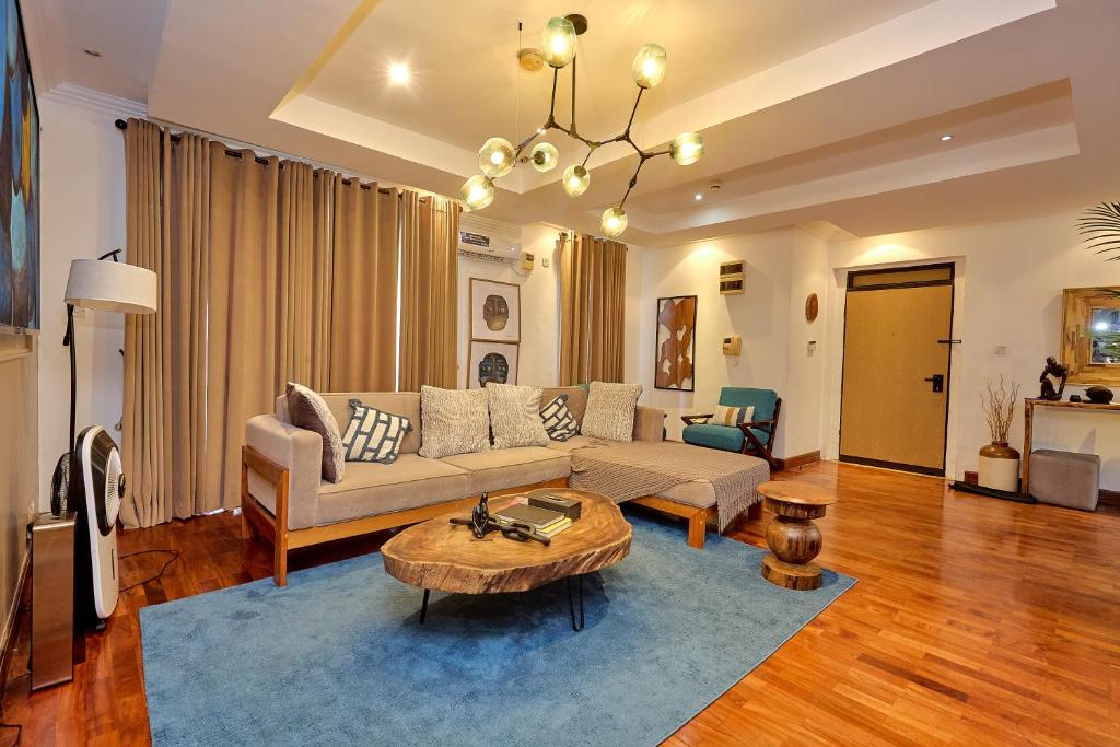 Lagos Residence - Luxury 4Bedroom Apartment Ikoyi في لاغوس: غرفة معيشة مع أريكة وطاولة قهوة