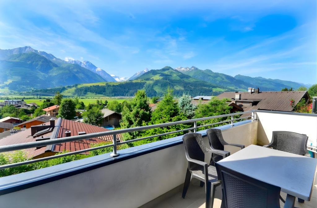 a balcony with chairs and a view of mountains at Kitzsteinhorn Kaprun Panorama in Dürnberg