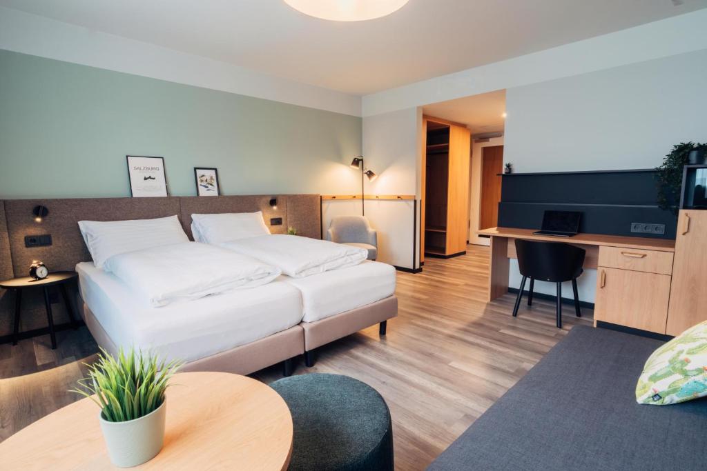 a hotel room with a bed and a desk at harry's home Salzburg in Salzburg