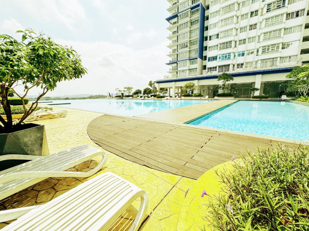 a swimming pool with two chairs and a building at Palmyra residence New condo in Kajang