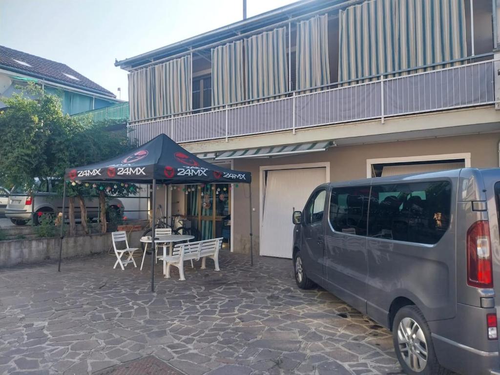 a van parked in front of a building with a table at Accommodation in the town center, on a private courtyard in CastellʼAlfero
