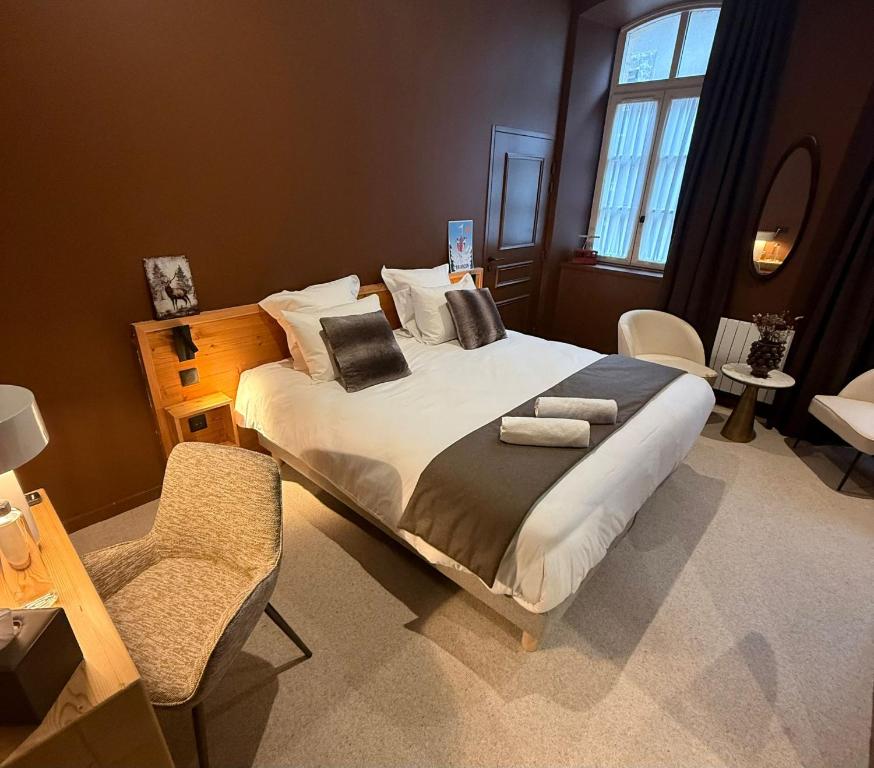 een slaapkamer met een groot bed en een stoel bij Maison Soyeuse in Briançon