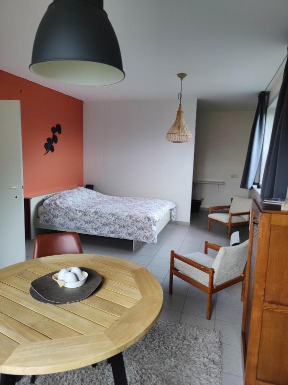 a living room with a table and a bedroom at De Drie Mussen in Diksmuide