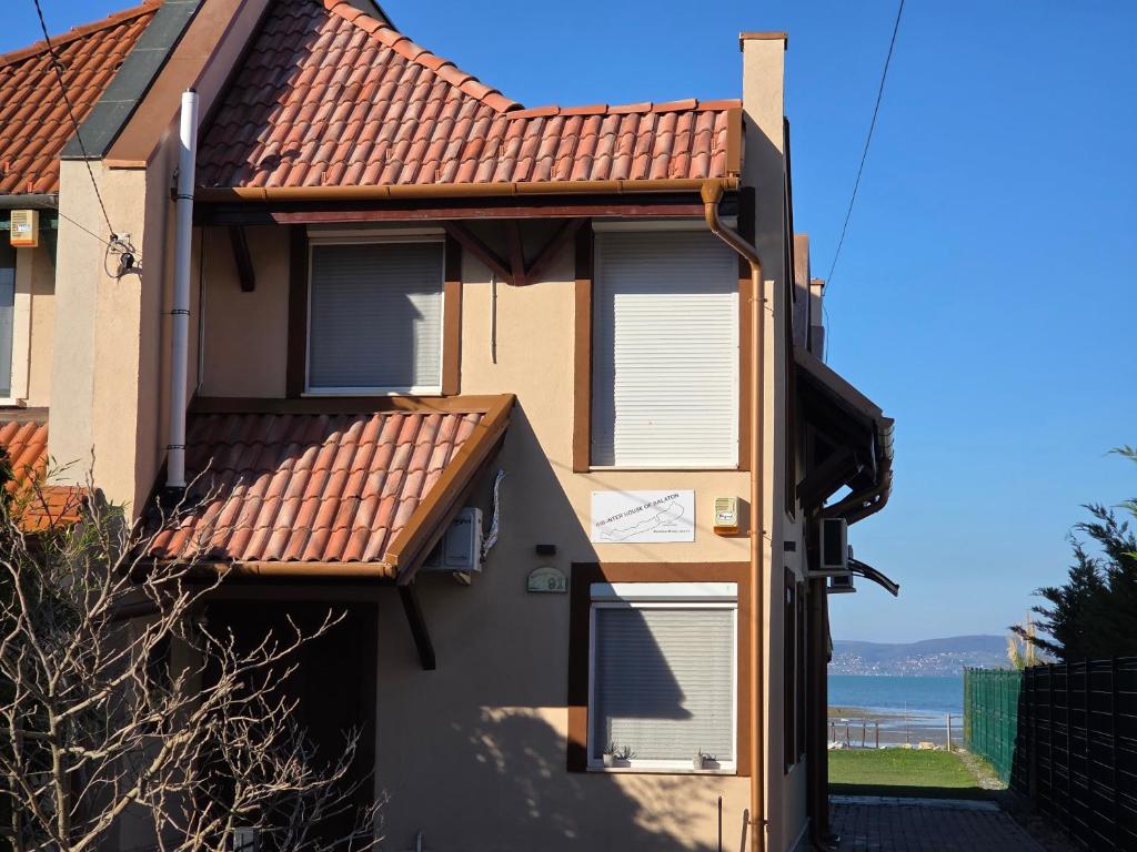 IHB-Inter House of Balaton في زاماردي: منزل ذو سقف من القرميد الأحمر وبوابة