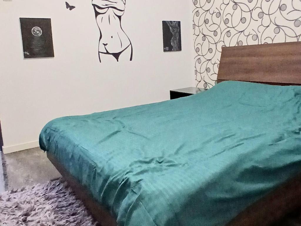 una camera da letto con un letto con un piumone verde sul muro di Walk-In Promenada a Craiova