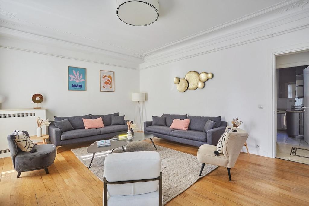 a living room with two couches and a table at Apartment Center of Paris Montmartre by Studio prestige in Paris
