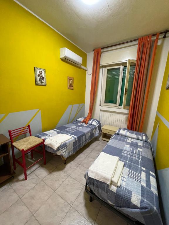 a room with two beds and a chair and a window at La Locanda del Re in Crevalcore
