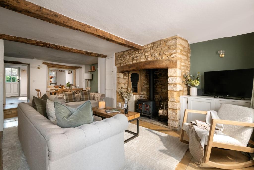 a living room with a couch and a fireplace at Magnolia Cottage-Exclusive Cotswold Package in Moreton in Marsh