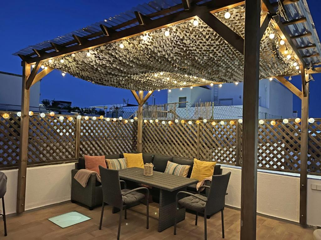 a patio with a table and chairs and lights at Casa Alice - Olhão By Junto ao Mar in Olhão