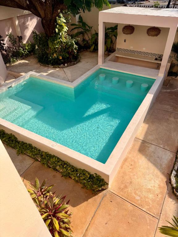an infinity pool in a backyard with a swimming poolificialificialificialificialificialificial at Acogedor estudio con piscina in Cancún