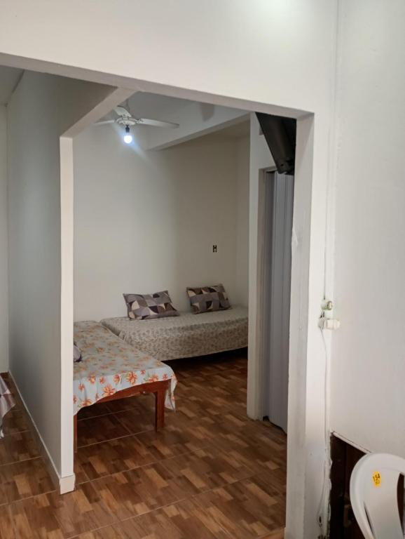 una camera con 2 letti in una stanza con pavimenti in legno di Casa Itacaré a Itacaré