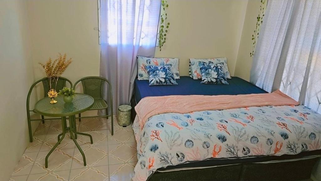 een kleine slaapkamer met een bed en een tafel bij Chaudhray accommodation in George